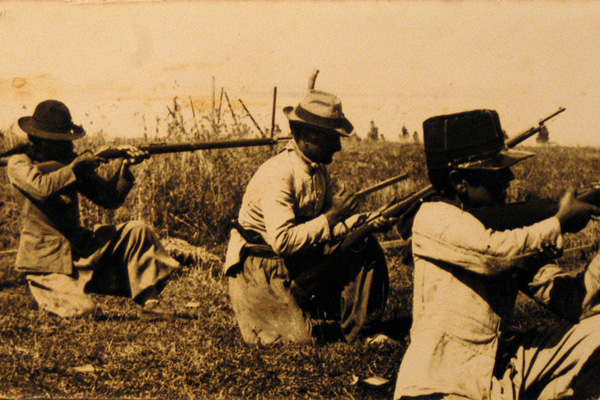 Fotografía de tres soldados apuntando con un arma.