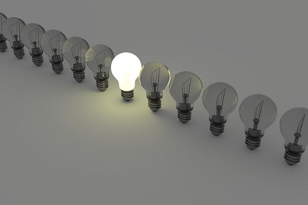 Fotografía de una fila de bomitas de luz, la del medio está encendida.