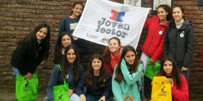 alumnos con morrales y banderas de joven lector