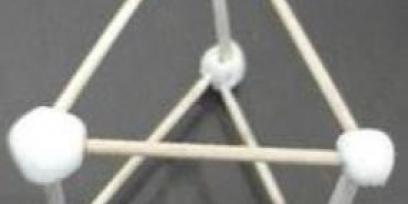 Representación de un prisma de base triangular con pajitas y bolitas