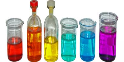frascos y vasos de Bohemia con soluciones de sales de metales de transición