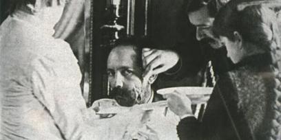Fotografía de Máximo Santos mientras tres personas curan heridas en su rostro. 