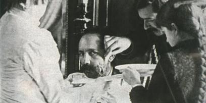 Fotografía de Máximo Santos mientras tres personas curan heridas en su rostro. 