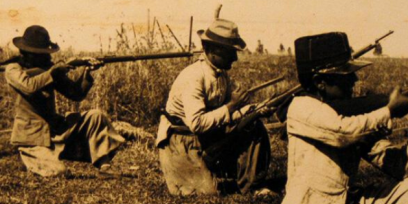 Fotografía de tres soldados apuntando con un arma.