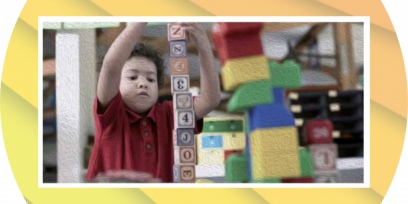 Niño construyendo una torre con cubos con letras.