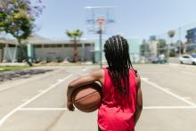 imagen decorativa de un niño con pelota de básquet entrando a una cancha abierta