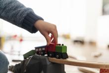 Fotografia de mano de niño jugando con un trencito