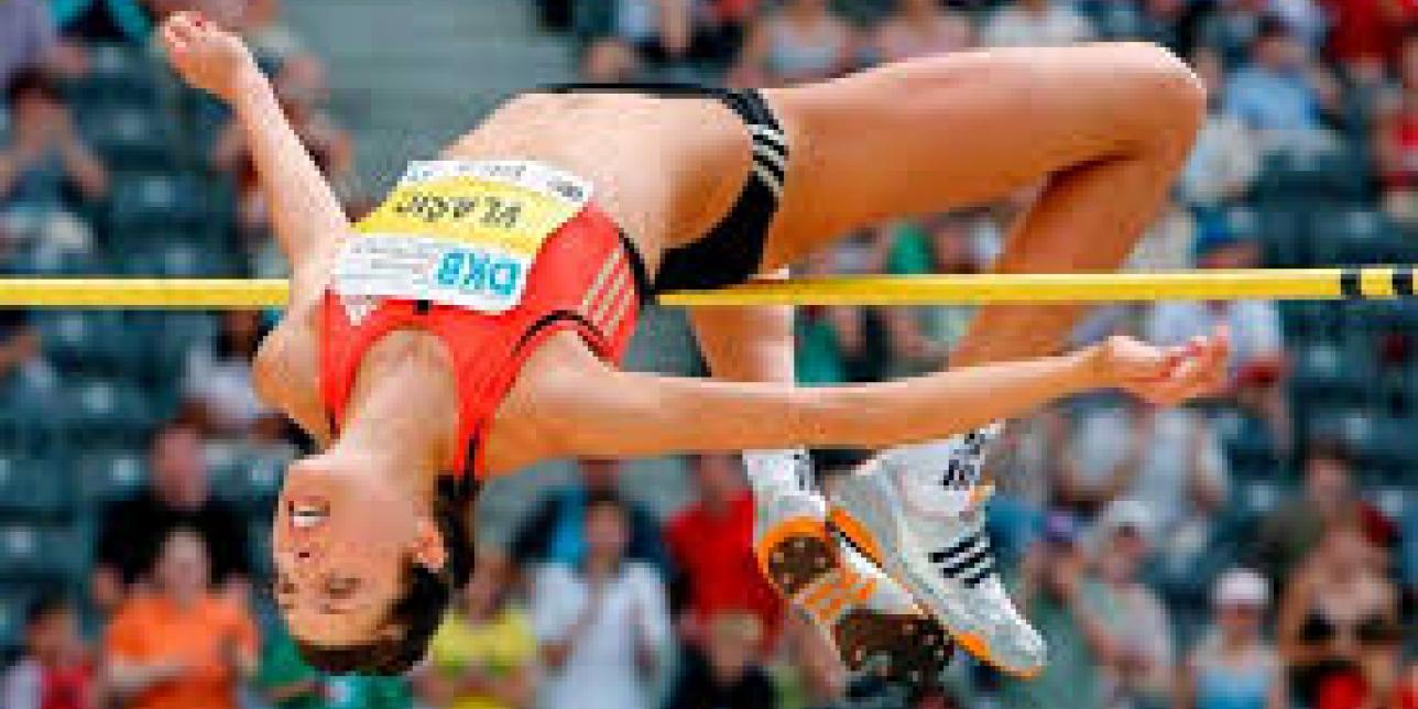 Atleta femenina realizando un salto en altura.