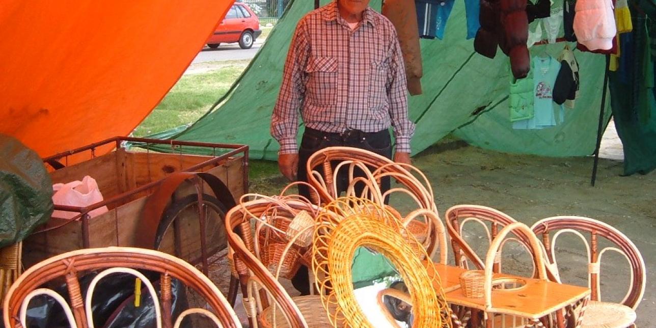  Artesano con productos fabricados en mimbre en una feria vecinal.