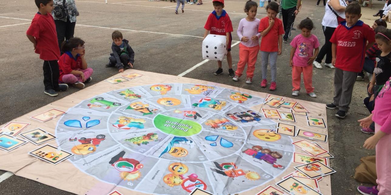 Niños en juego interactivo grande en plaza de deportes.