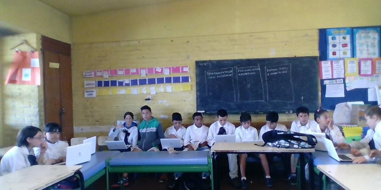 Alumnos de sexto año en clase usando laptops