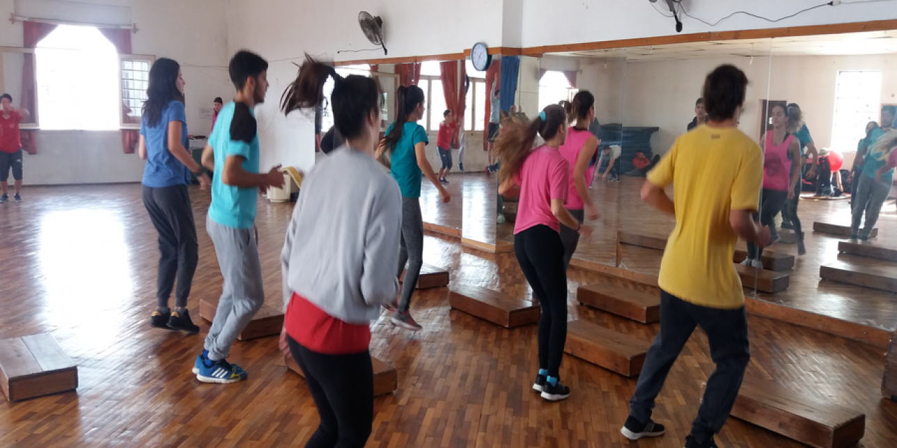 Jóvenes realizando entrada en calor con cajones o steps.