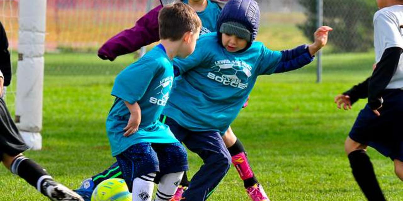 Niños y niñas jugando fútbol