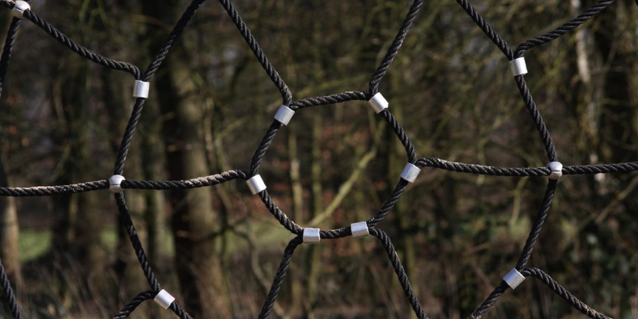 Juego de parque para trepa, con forma de telaraña, con círculos concéntricos y conexiones entre ellos con cuerdas.