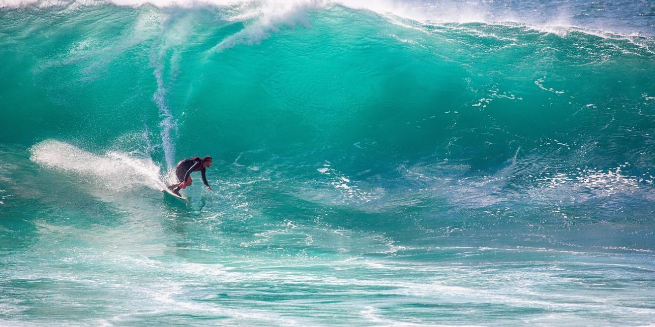 Surfista corriendo una ola