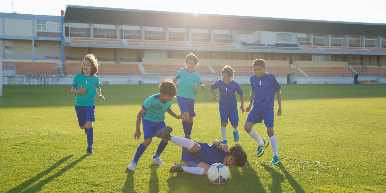 Imagen decorativa, con niños jugando al fútbol sonrientes