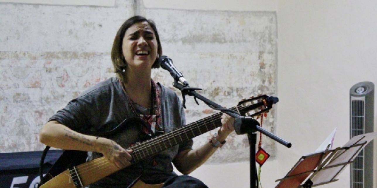 Mujer cantando y tocando la guitarra