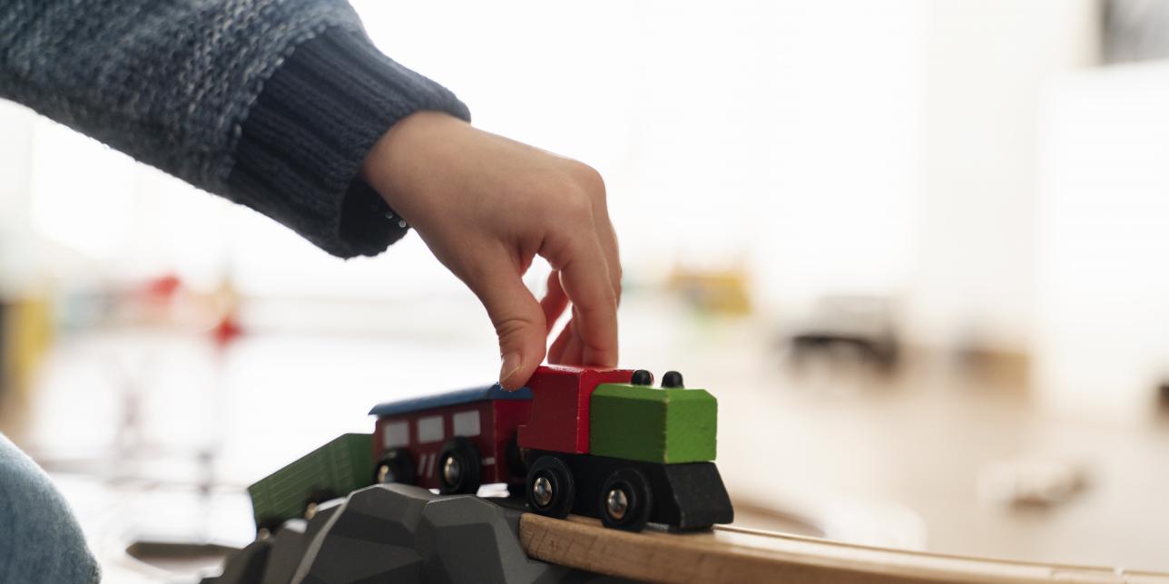 Fotografia de mano de niño jugando con un trencito
