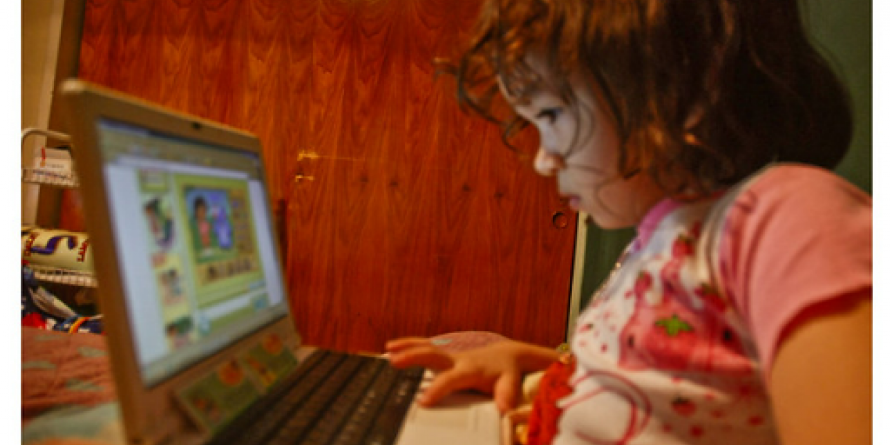niña pequeña mirando la pantalla de una computadora